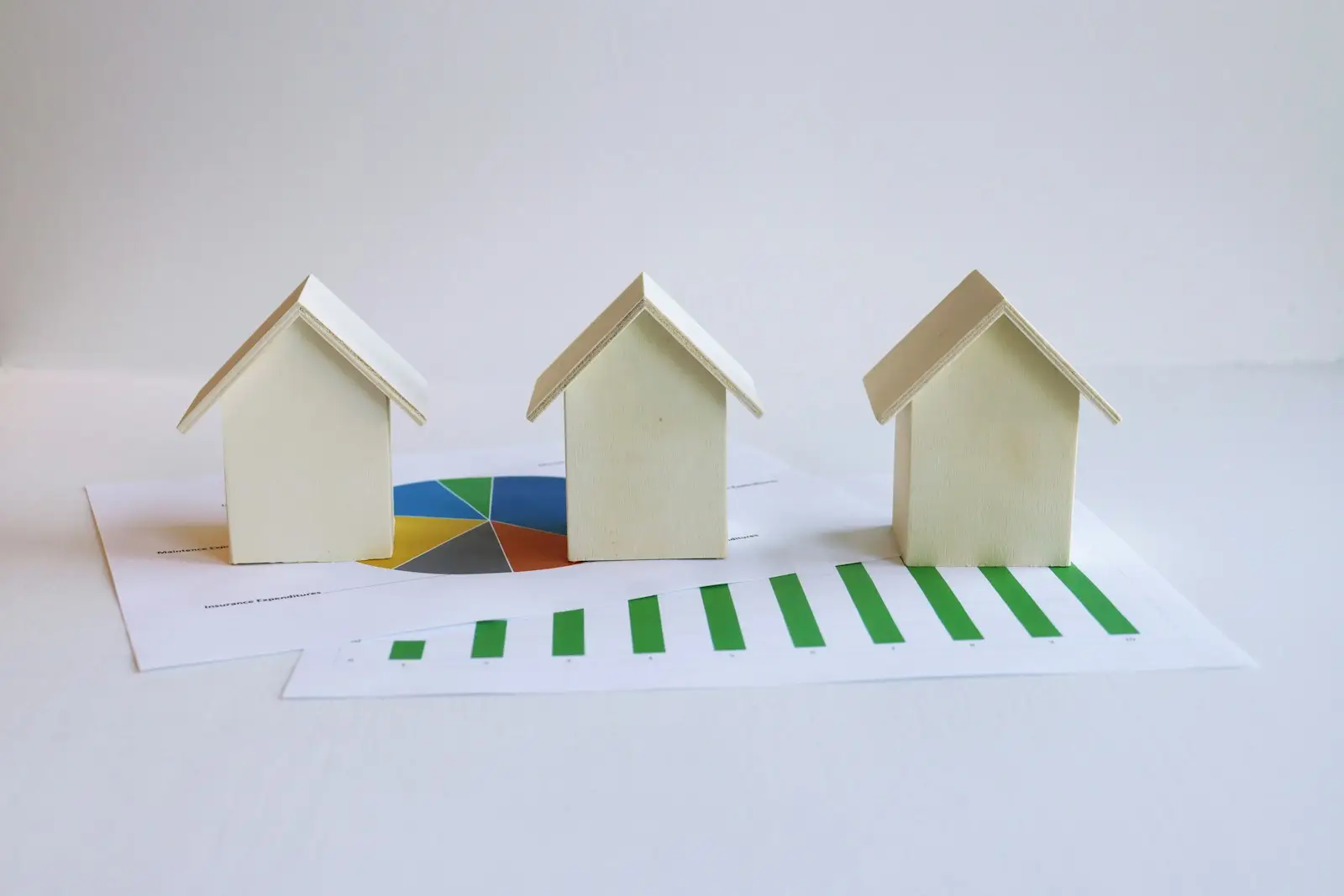 three small houses sitting on top of a piece of paper