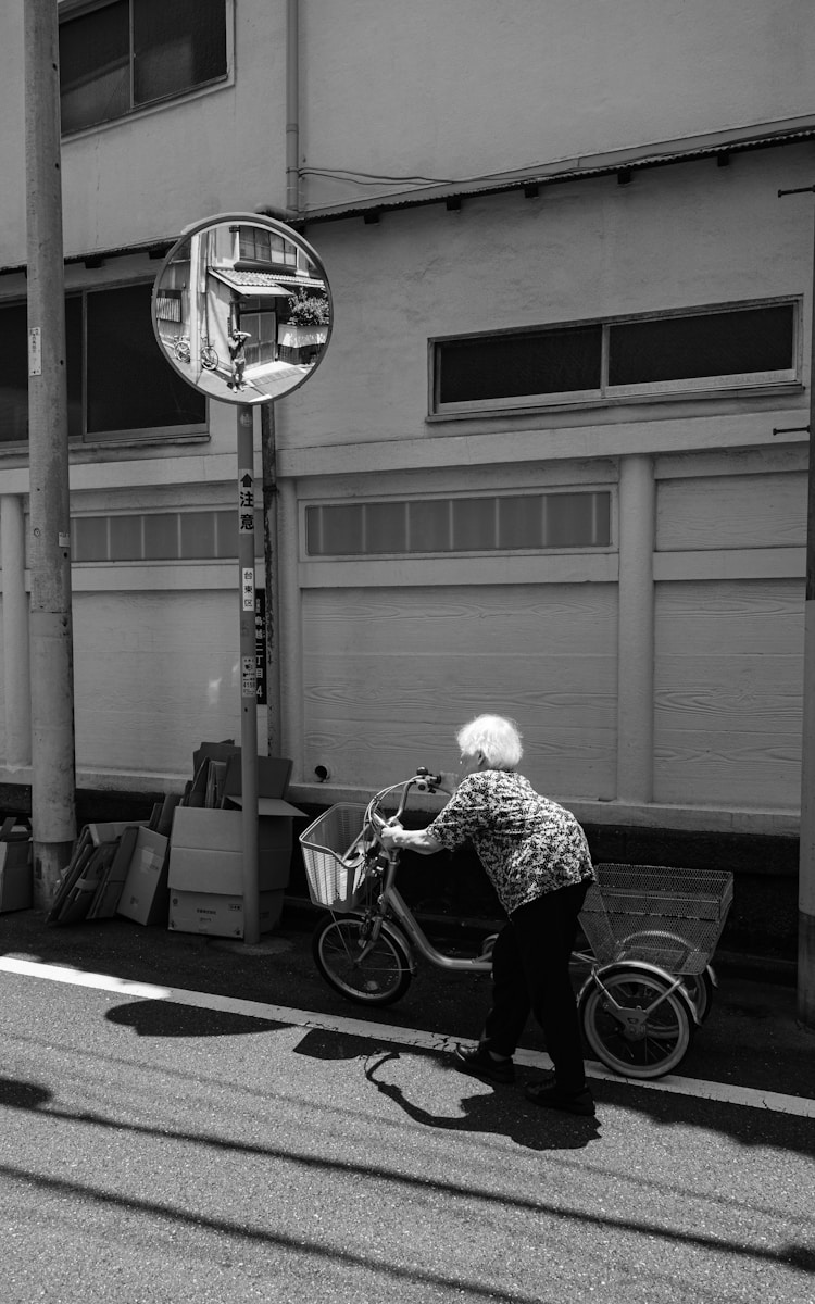 A woman riding a bike down a street next to a tall building
