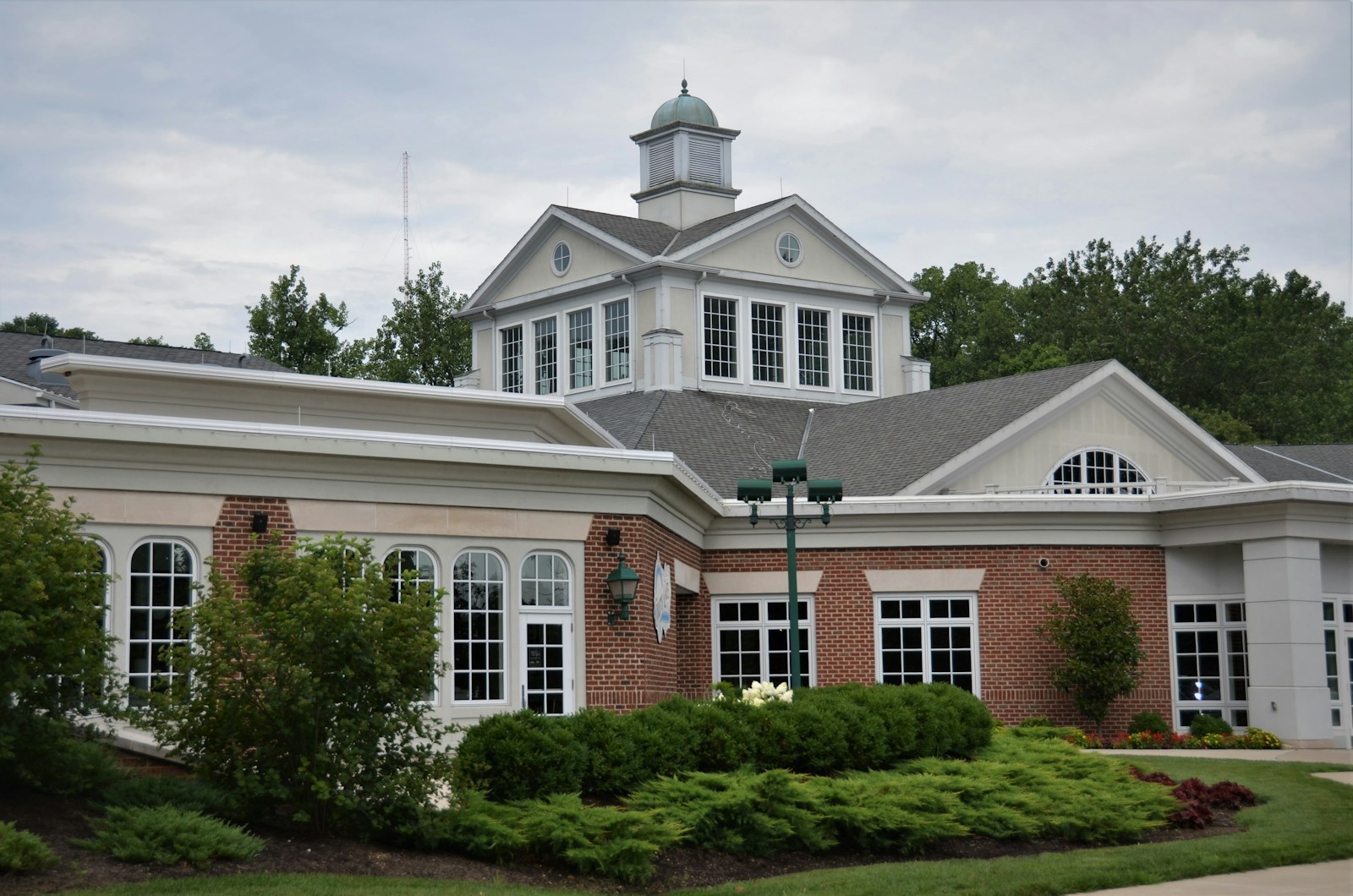 a large brick building with a green lawn in front of it