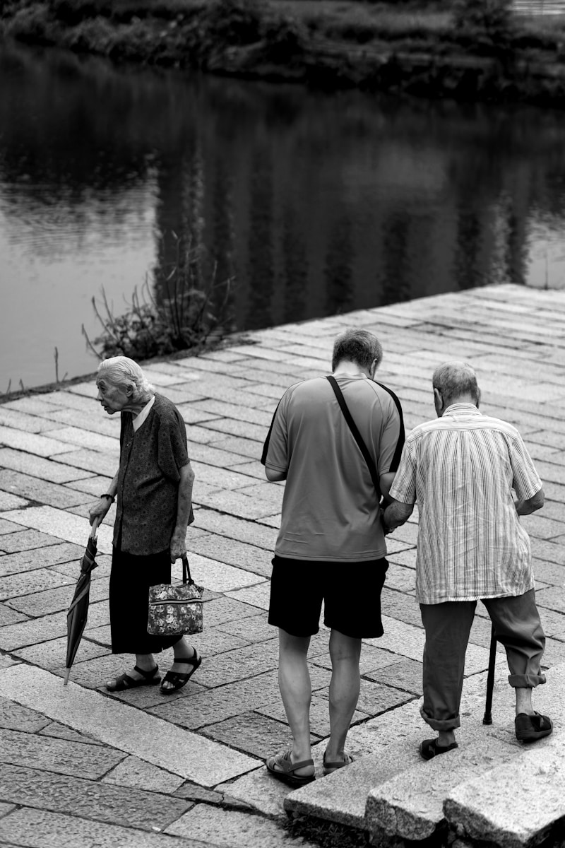 three people walking on platform near body of water